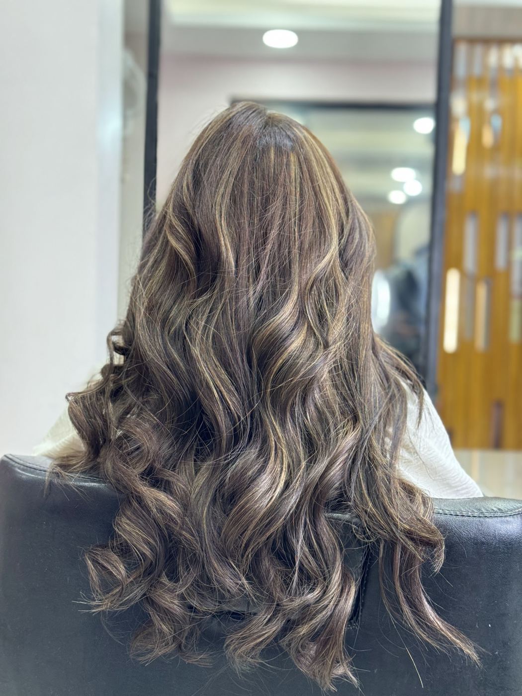 Long, soft ash-brown balayage waves seen from behind.