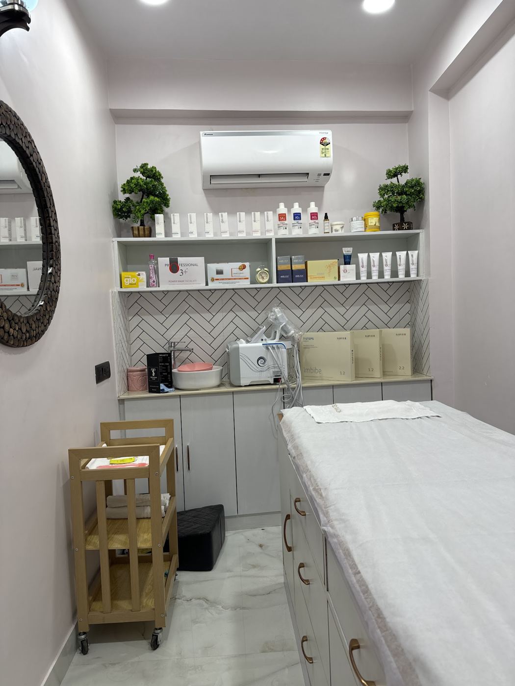 Private facial room with a treatment bed and shelves of skincare products.