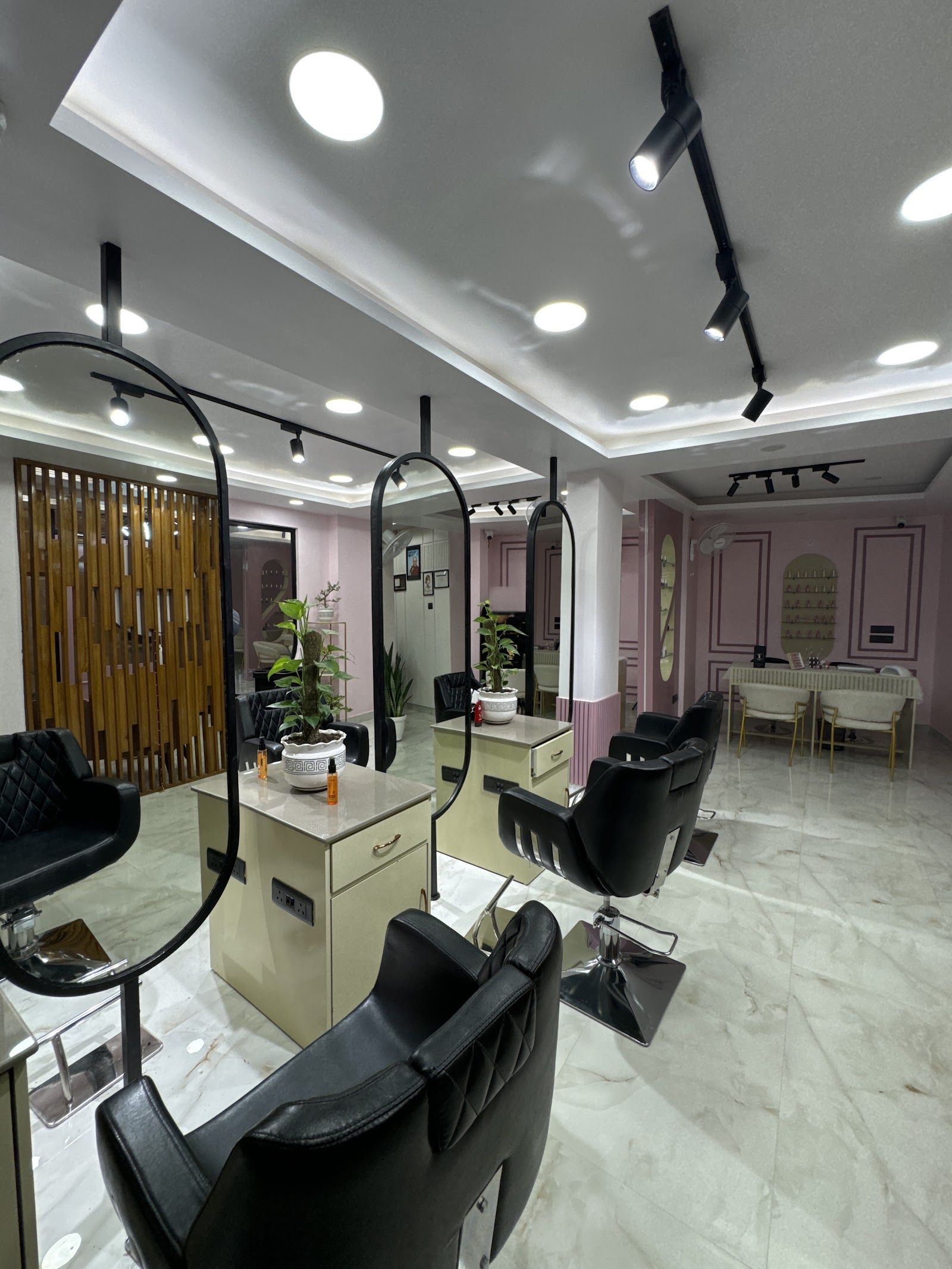 Inside Ted Salon on the 4th floor: black styling chairs, tall oval mirrors, teak wood slats and blush-pink walls over a marble floor.
