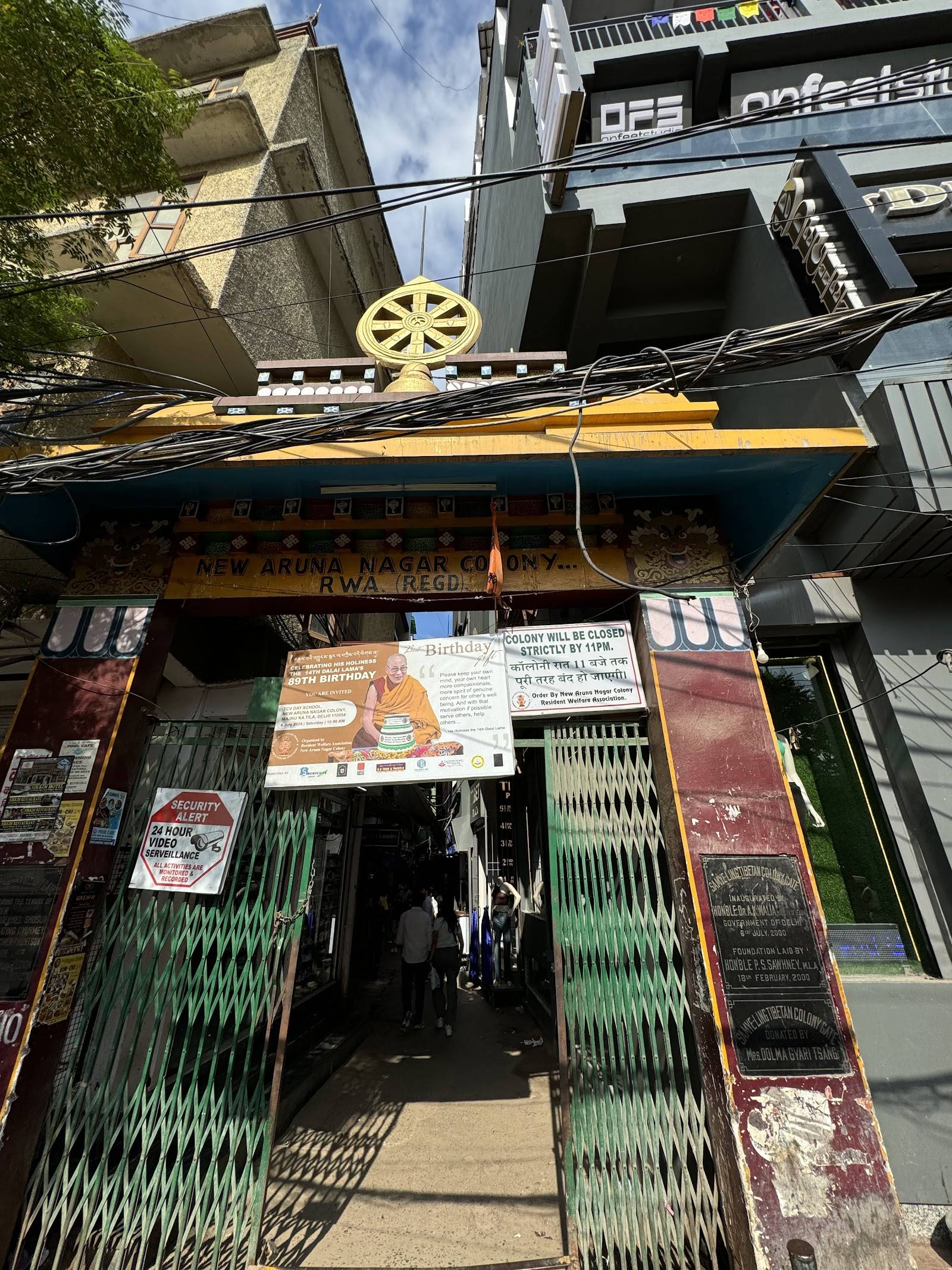 The main gate of Majnu ka Tilla, Delhi's Little Tibet, with the golden Dharma wheel above the entrance.
