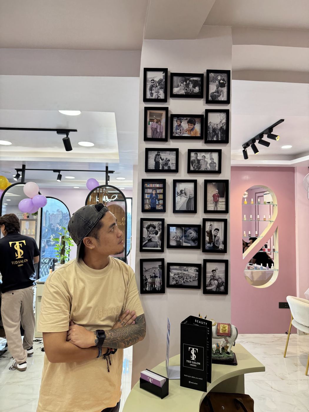A guest looking over the portrait wall of framed black-and-white photos beside reception.