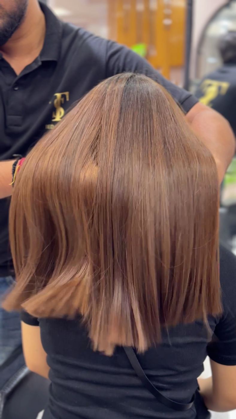 Sleek, glossy shoulder-length cut being finished by a Ted Salon stylist.